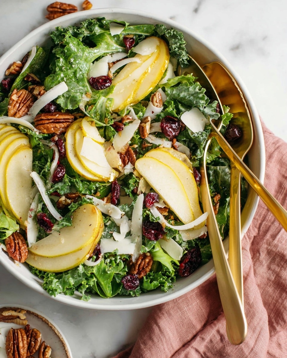 A fresh salad in a deep white bowl sits on a white marbled surface with a soft pink cloth nearby. The salad has three main layers: the base is made of bright green leafy mixed greens and kale, topped with thin yellow-green slices of pear, scattered halves of toasted pecans, and small dark red dried cranberries. Thin white onion slices and large light cream cheese shavings are spread evenly on top. A pair of gold salad tongs rests inside the bowl, slightly lifting some greens and pear slices. Photo taken with an iphone --ar 4:5 --v 7