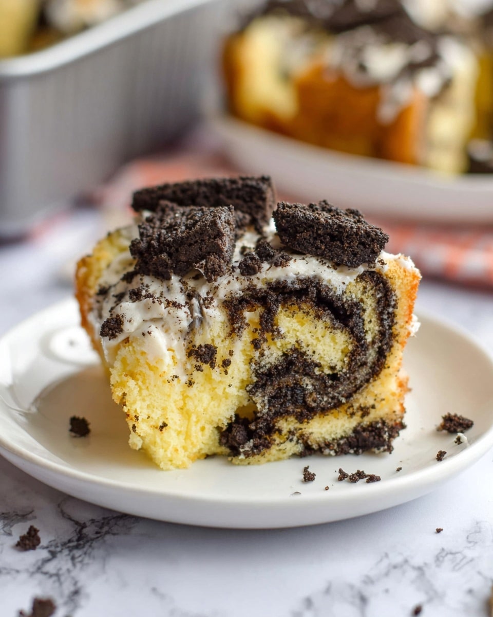 A close-up of a piece of soft, light yellow cake twisted with dark brown crushed cookie crumbs, showing a swirled texture inside; the top layer is covered with a thin layer of white frosting and some larger broken cookie pieces scattered on top; the cake sits on a white plate placed on a white marbled surface, with a blurred cake pan in the background. Photo taken with an iphone --ar 4:5 --v 7