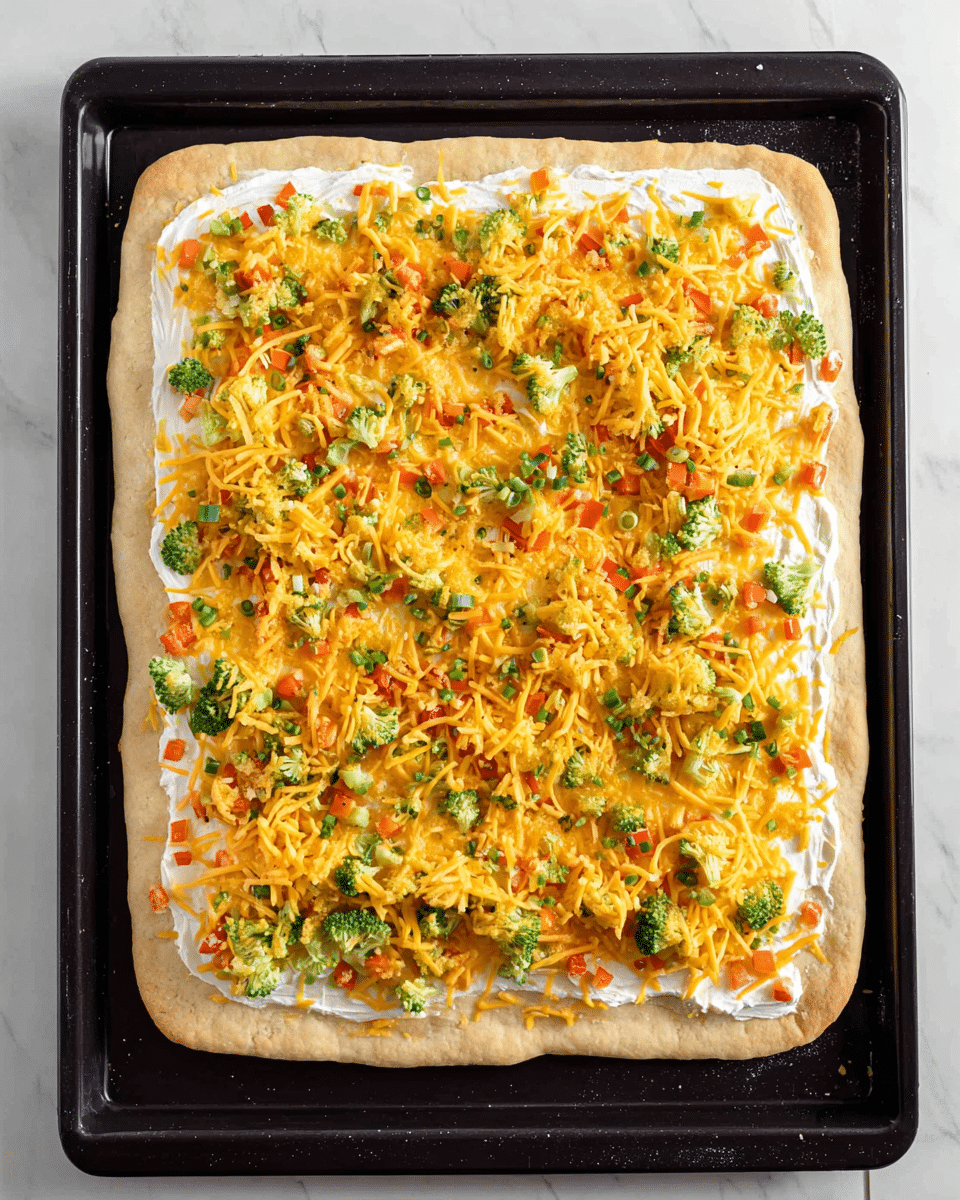 The image shows six square pieces of a colorful vegetable pizza arranged on a wooden board. Each piece has three layers: a thick, golden brown crust base; a creamy white sauce layer spread evenly on top; and a vibrant vegetable topping made of bright green broccoli florets, shredded orange carrots, diced red bell peppers, chopped green onions, and shredded yellow cheddar cheese scattered generously. In the background, more pieces of the pizza sit on a white plate and a black pan, all placed on a white marbled surface. Photo taken with an iphone --ar 4:5 --v 7