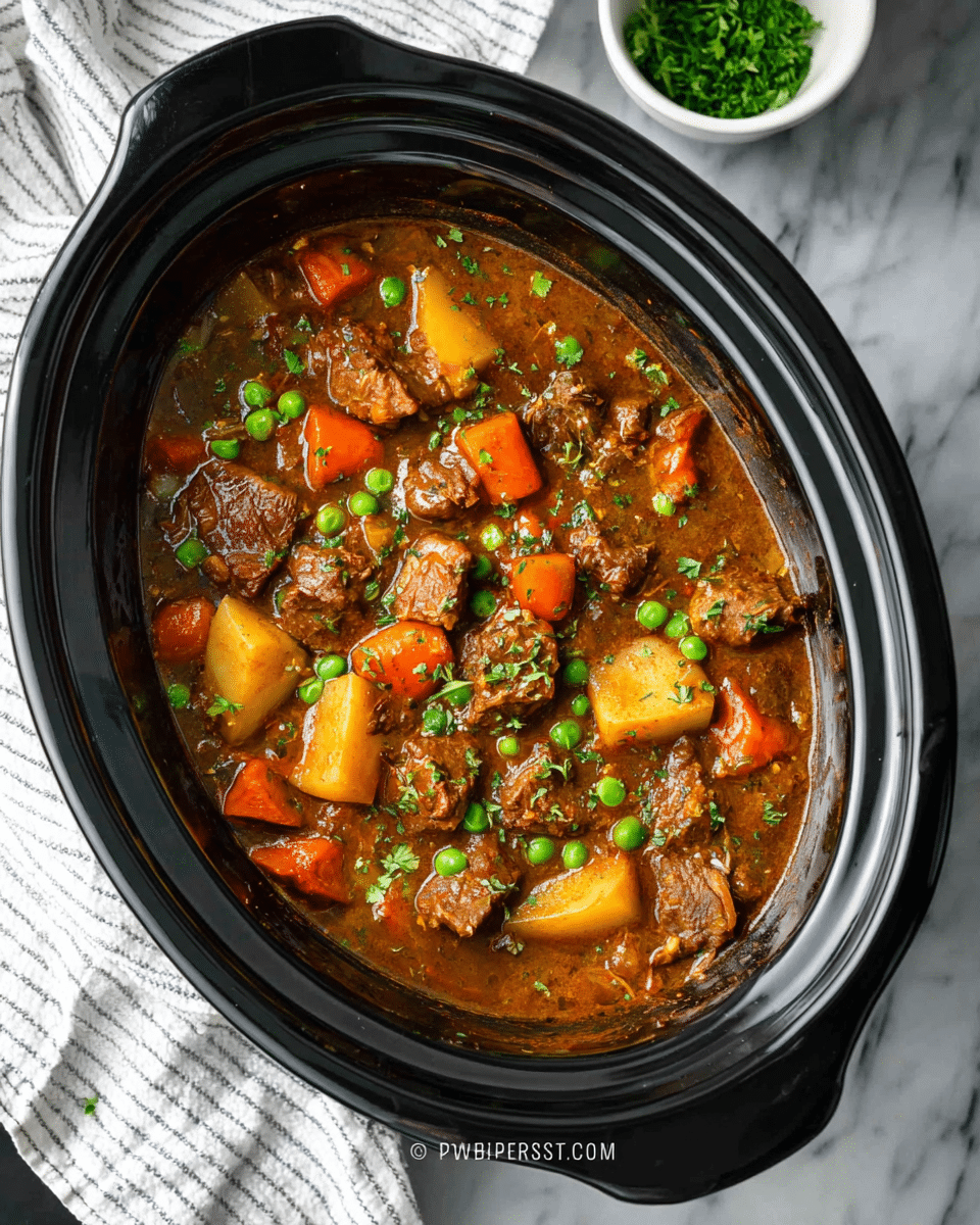 The image shows a black slow cooker filled with a thick stew. The stew has layers of brown gravy mixed with chunks of tender brown meat, bright orange carrot pieces, light yellow potato chunks, green peas scattered all over, and bits of celery. Small green herb sprinkles are spread on top for garnish. The slow cooker is placed on a white marbled surface next to a white and grey striped cloth, with a small white bowl containing chopped green herbs in the background. Photo taken with an iphone --ar 4:5 --v 7