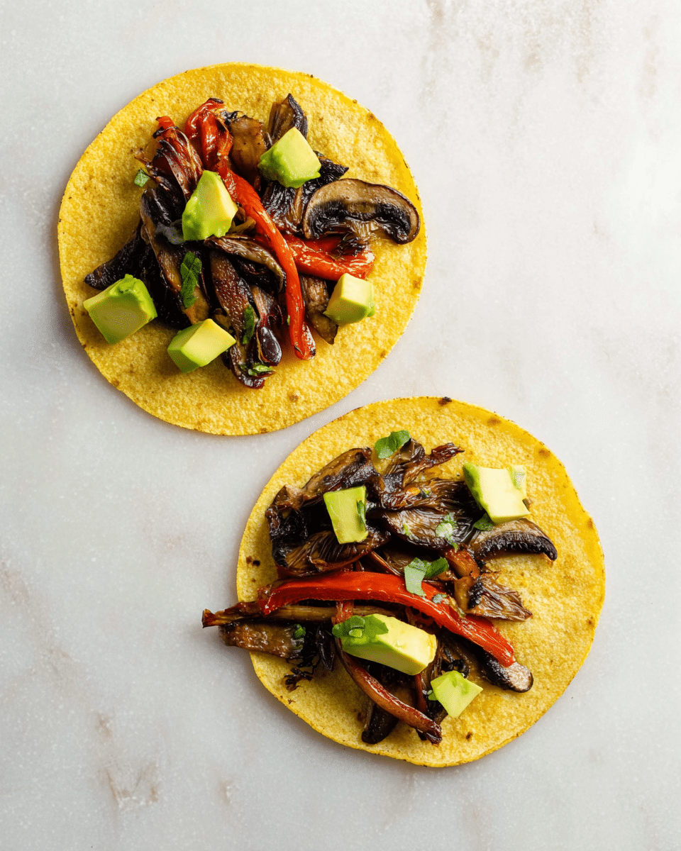 Two open corn tortillas lie flat on a white marbled surface, each topped with a simple layer of ingredients. On both tortillas, sautéed dark brown mushrooms and thin red pepper strips are placed in the center, with small green avocado cubes scattered on top and around them, creating a fresh and colorful contrast on the yellow corn base. The texture of the tortillas shows light grill marks. photo taken with an iphone --ar 4:5 --v 7