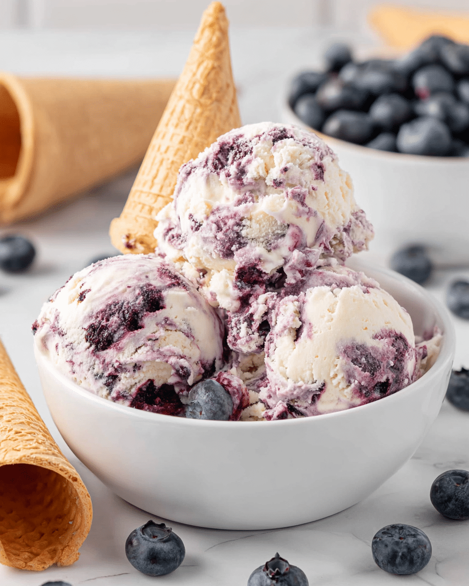 A white bowl is filled with purple and white swirled blueberry ice cream scoops, with a light brown waffle cone placed upside down on top of the scoops. Around the bowl, whole fresh blueberries are scattered on a white marbled surface. One extra empty light brown waffle cone lies on its side in the front left of the image, and a blurred white bowl full of blueberries is visible in the background. The ice cream has a creamy texture with visible blueberry bits mixed in. photo taken with an iphone --ar 4:5 --v 7