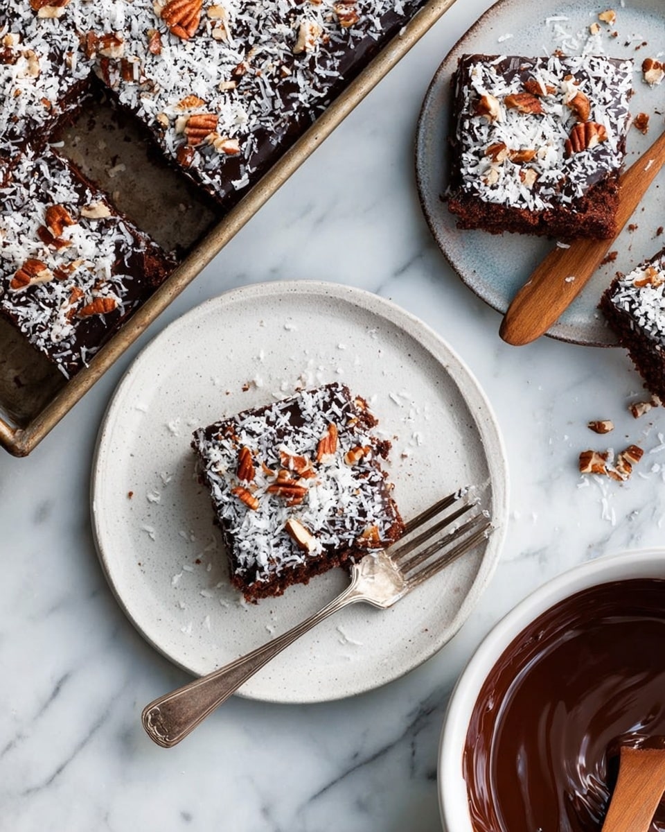 The image shows a square chocolate cake cut into pieces and topped with a thick layer of dark chocolate frosting, sprinkled evenly with white shredded coconut and chopped pecans. The cake itself appears moist and dense with a rich brown color. One piece is placed on a white round plate with a slightly textured surface, next to a vintage silver fork resting on the plate's edge. The cake pan holds the remaining cake, with a few pieces cut out, all topped in the same way. A white bowl filled with glossy melted chocolate and a wooden spoon is also visible. The setting is on a white marbled surface. Photo taken with an iphone --ar 4:5 --v 7