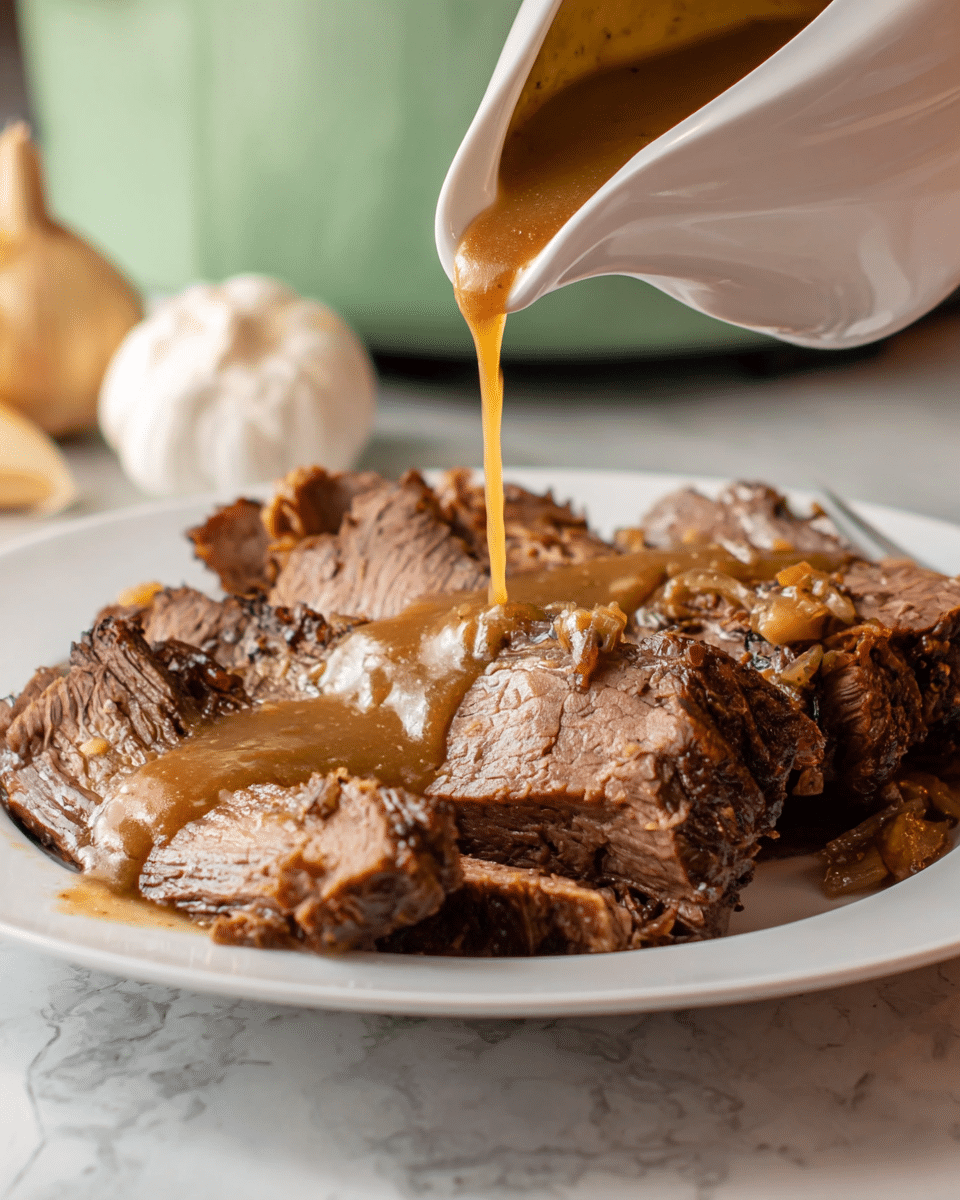 A white plate filled with several pieces of sliced, cooked beef showing a mix of brown, pink, and slightly charred textures, with juicy, tender meat visible inside. A light brown gravy with a smooth texture is being poured from a white gravy boat, flowing in a thick stream and coating the meat in the center of the plate. The background features a whole garlic bulb and a light green object softly blurred, with the setup on a white marbled surface. Photo taken with an iphone --ar 4:5 --v 7