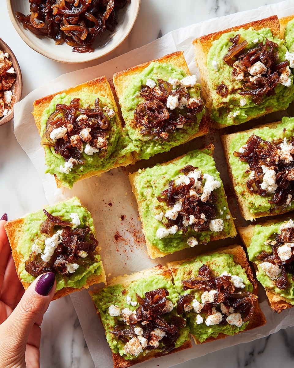 The image shows eight square pieces of bread topped with three layers: a golden brown crust at the bottom, a thick spread of bright green mashed avocado in the middle, and a topping of dark brown caramelized onions and small white crumbles sprinkled with a reddish spice on top. The pieces are arranged closely on white parchment paper over a white marbled surface. A woman's hand with dark purple nail polish is holding one piece on the left side. Two small bowls, one filled with caramelized onions and the other with the reddish white crumbles, are also visible on the left side. Photo taken with an iphone --ar 4:5 --v 7
