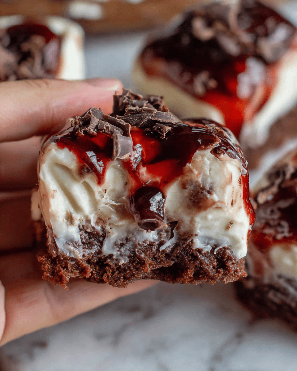 A close-up of a small dessert held by a woman's hand, showing three visible layers: a bottom layer of dark brown cake, a thick middle layer of smooth white frosting, and an uneven top layer featuring glossy dark red syrup drizzled over the white frosting with small dark chocolate shavings scattered on top. The dessert is on a white marbled surface with blurred parts of more cake pieces in the background. Photo taken with an iphone --ar 4:5 --v 7