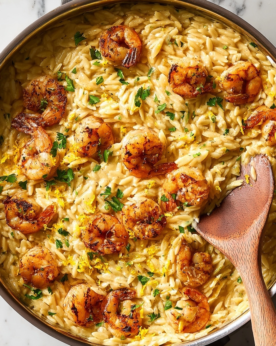 A close-up view of a cooked shrimp and orzo dish in a large metal pan, with a wooden spoon lifting a scoop of creamy, light golden orzo pasta mixed with browned shrimp. The shrimp are golden with a slightly crispy texture and some are garnished with small green parsley leaves. The orzo noodles are coated in a rich, creamy sauce that fills the pan, and more parsley leaves are scattered on top. The background is a white marbled surface. Photo taken with an iphone --ar 4:5 --v 7