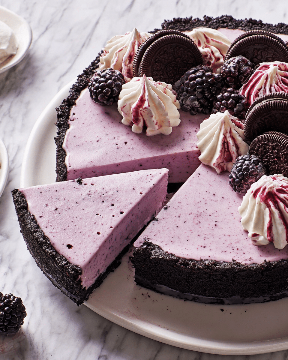 A three-layered tart with a dark chocolate crumb crust forming the base and edges, topped with a smooth, light purple creamy layer that has tiny specks inside. One slice is partly removed, showing the clean edge of the purple layer. The tart is decorated on one side with swirled white cream that is lightly stained with purple streaks and blackberries placed on top along with small dark chocolate sandwich cookies. The whole dessert sits on a white plate over a white marbled textured surface. Photo taken with an iphone --ar 4:5 --v 7