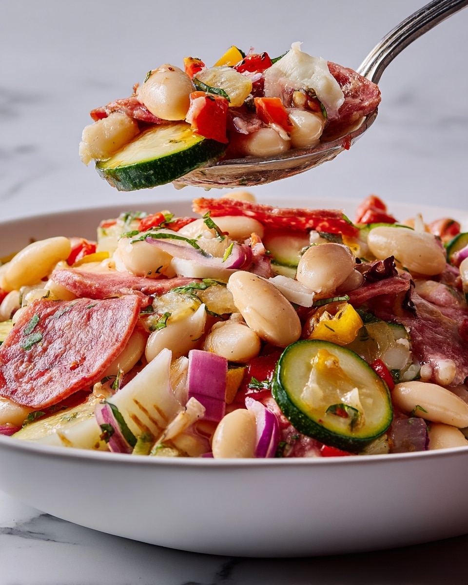 The dish is a colorful bean salad served in a white bowl with a white marbled surface in the background. It has several layers, starting with large white beans forming the base. Above this are slices of white and green zucchini and thin, circular slices of red salami. Scattered throughout are small chunks of white cheese, likely mozzarella, and diced red onions. There are also small pieces of red and yellow peppers, and some green herbs sprinkled on top. The textures vary from smooth beans and cheese to crisp vegetables and thin, slightly shiny salami slices. A spoonful of the salad is being lifted, showing the mix of all these colorful ingredients closely. Photo taken with an iphone --ar 4:5 --v 7