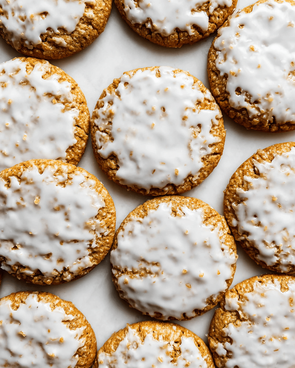 The image shows several round cookies tightly arranged on a flat white marbled surface. Each cookie has a golden-brown base layer with a rough, slightly cracked texture, and the top layer is unevenly coated with white icing that spreads across the surface in irregular patterns, leaving some parts of the cookie base visible. The cookies are uniform in size and shape, with the icing looking glossy and slightly hardened. The overall look is neat with the cookies touching each other, filling the frame. photo taken with an iphone --ar 4:5 --v 7