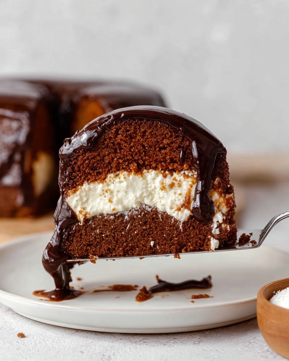 The image shows a close-up of a thick slice of moist brown cake with a creamy white filling layer in the middle. The cake is covered with a shiny drizzle of dark chocolate sauce that glistens as it runs down the sides. The slice is being held on a silver cake spatula, with the white plate below catching some drips of the chocolate. The background has a soft white marbled texture, and in the foreground on the lower right corner, there is a small wooden bowl with a white substance inside. photo taken with an iphone --ar 4:5 --v 7
