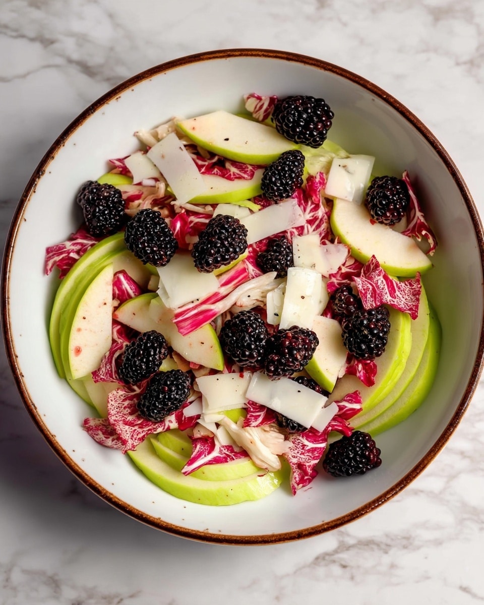 The image shows a fresh salad in a white bowl with a brown rim, placed on a white marbled surface. The salad has three main layers: the base layer is made of sliced light green apple pieces spread evenly, the middle layer consists of bright pink and white leafy radicchio, and the top layer is sprinkled with dark purple blackberries and thin white cheese flakes scattered throughout. The textures vary from crisp apple slices to soft leaves and bumpy glossy blackberries. Photo taken with an iphone --ar 4:5 --v 7